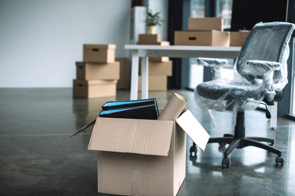 cardboard box with folders and office supplies in floor during r